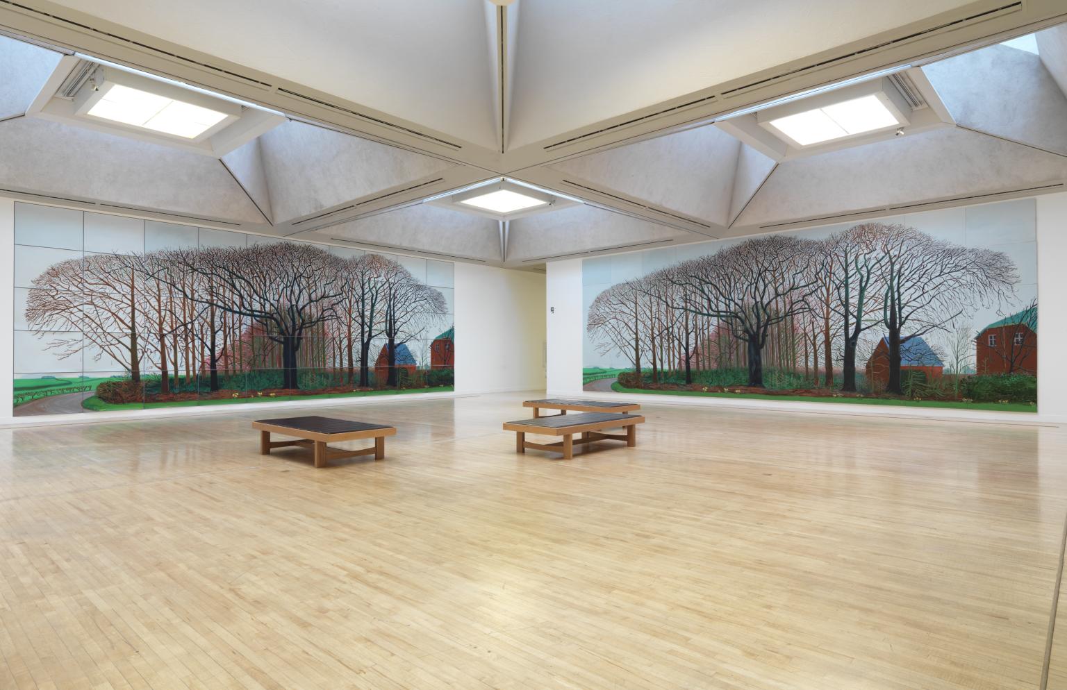 David Hockney, Bigger Trees Near Warter, 2007: a very wide landscape made from many joined panels, showing leafless trees, a path, winter grass, and a dense Yorkshire hedge under a pale sky.
